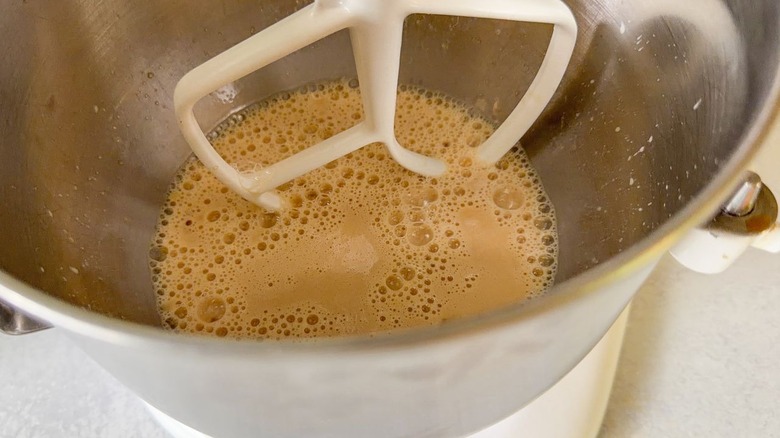 Beinet dough liquid ingredients in stand mixer bowl with paddle attachment