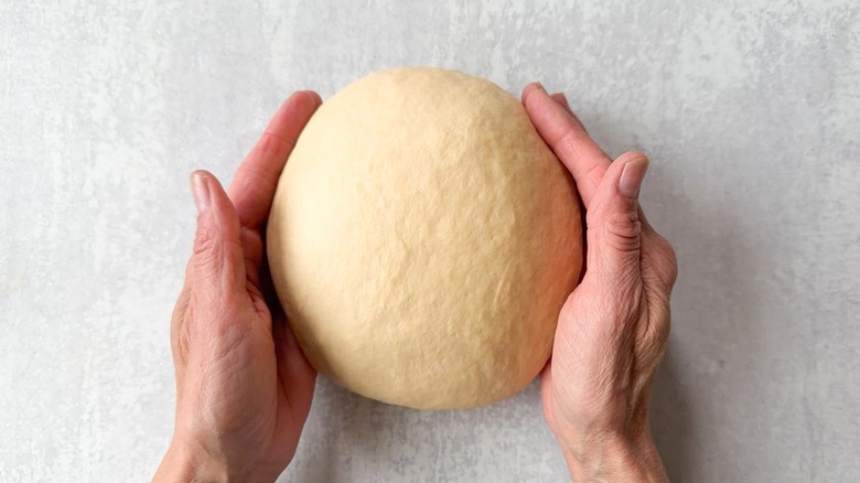 Shaping beignet dough into a smooth ball