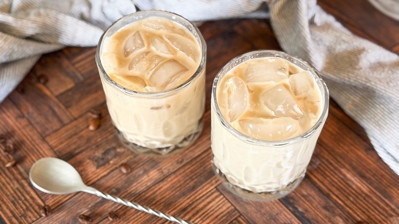 Classic White Russian cocktails in rocks glasses with spoon and coffee beans