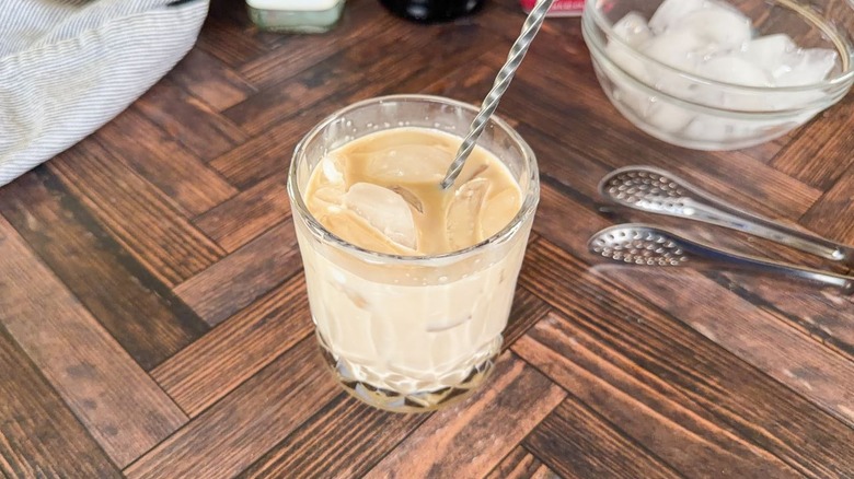 Stirring classic White Russian cocktail in rocks glass