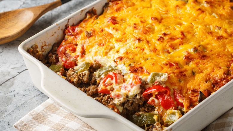 A hot casserole fresh out of the oven, with peppers, ground beef, and topped with cheese
