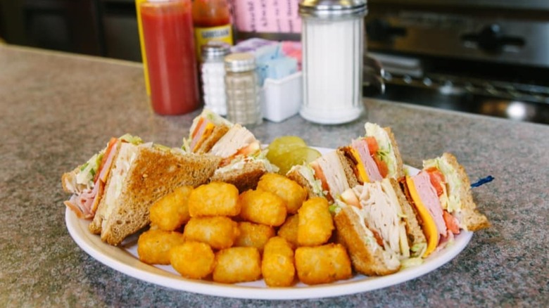 Clover Grill's club sandwich and tater tots on the diner counter