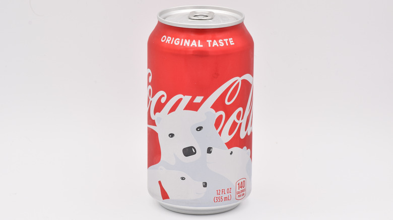 Polar bear holding a glass bottle of Coca-Cola