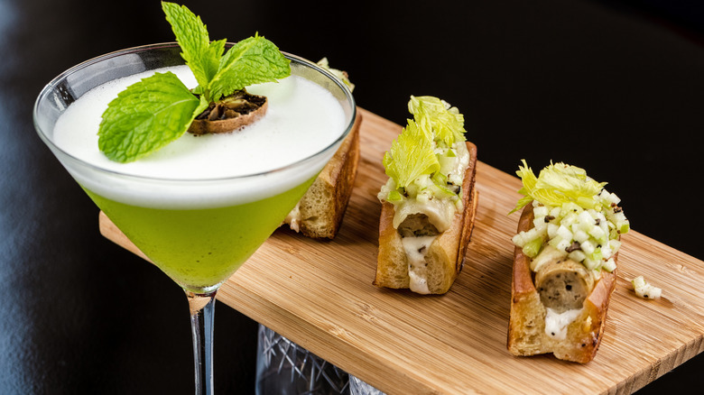 Fresh lime and mint cocktail with appetizer on the side