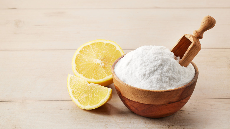 Baking soda and sliced lemon on a light brown table