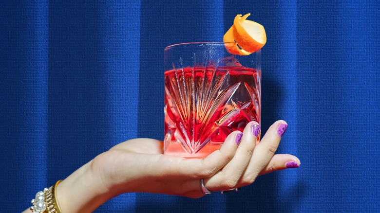 Hand holding Negroni cocktail