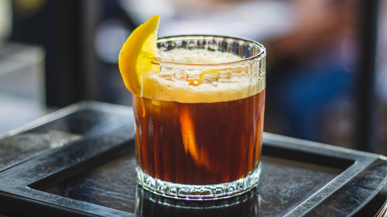 A mazagran cocktail garnished with a slice of lemon