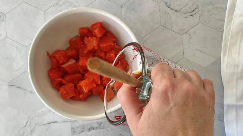 pouring marinade on salmon chunks