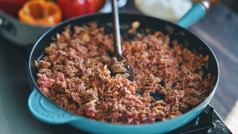 Ground meat cooks on the stovetop.
