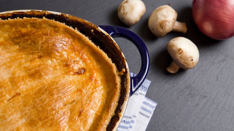 Chicken pot pie with golden brown top in a dish.