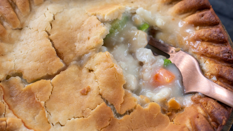 Chicken pot pie with fork and filling.