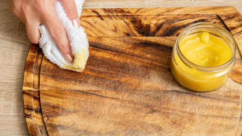 Woman applying beeswax to board