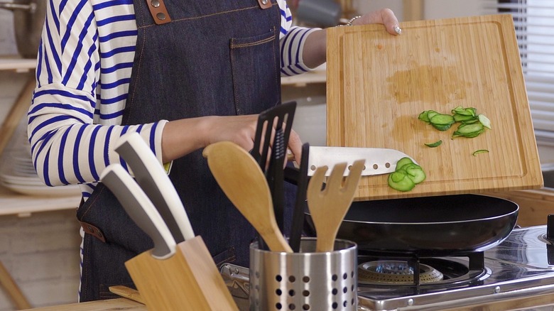 Woman scraping food off board