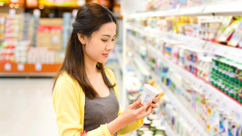 Woman choosing yogurt at store