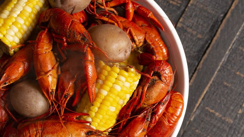 A close up of a crawfish boil with corn and potatoes