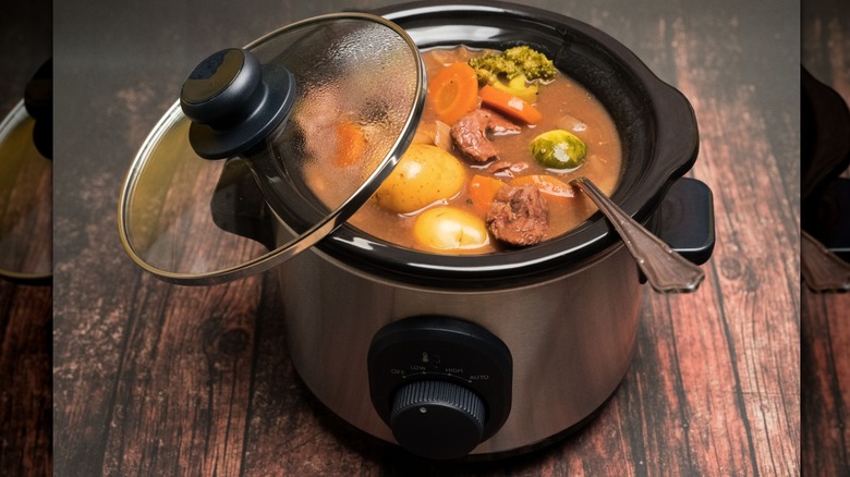 Beef stew in a crock pot with open lid.