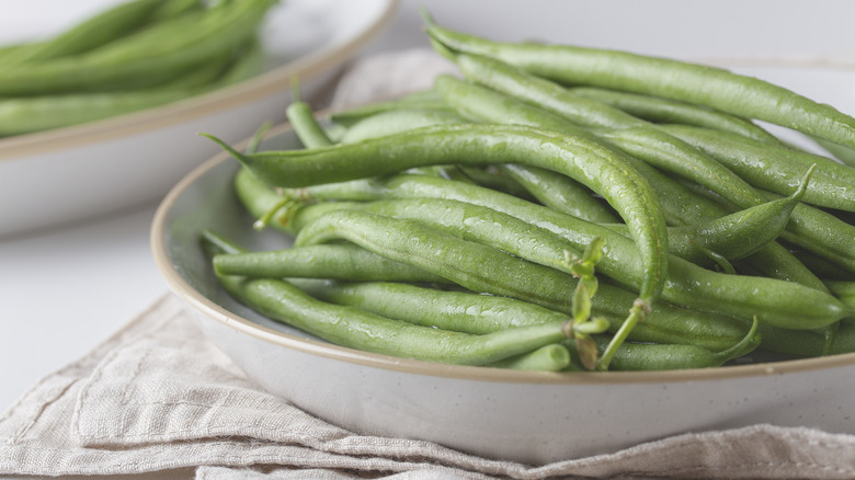 fresh green beans on white plates