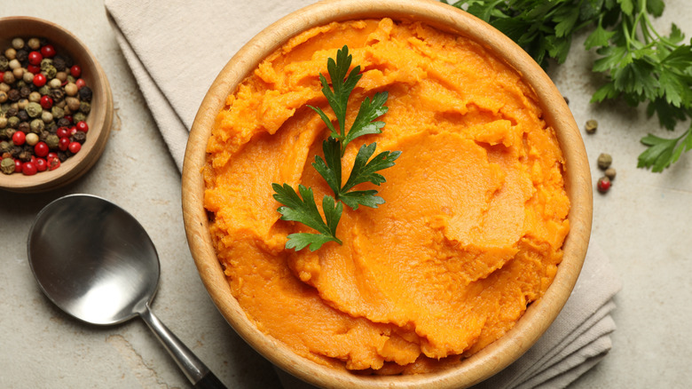 Bowl of mashed sweet potatoes topped with parsley