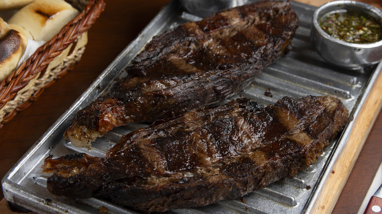 Two grilled skirt steaks on a metal tray