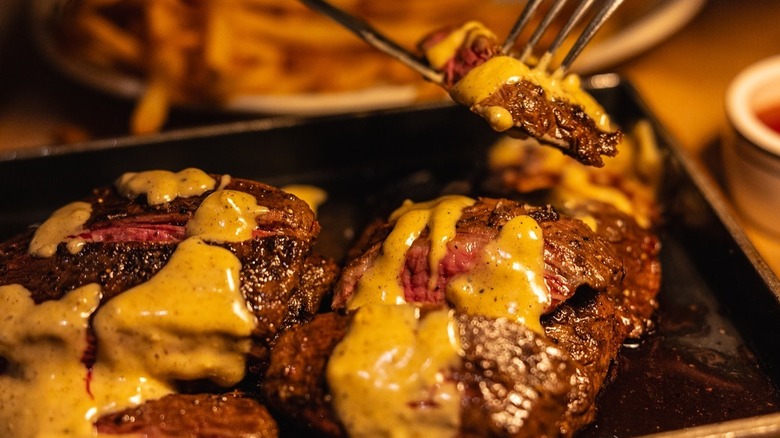 A skirt steak at Skirt Steak, NYC sliced and drizzled with béarnaise sauce