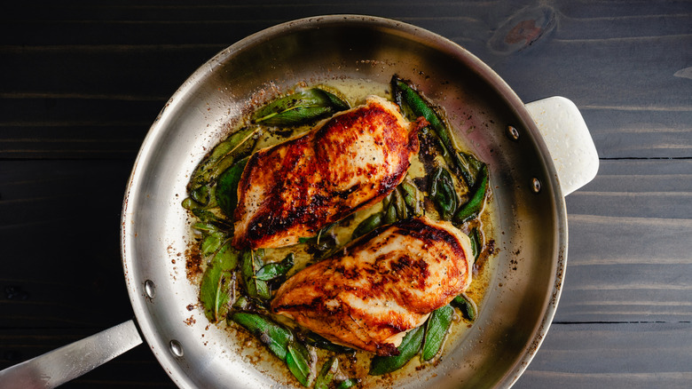Seared chicken breast cooked in a stainless steel pan.