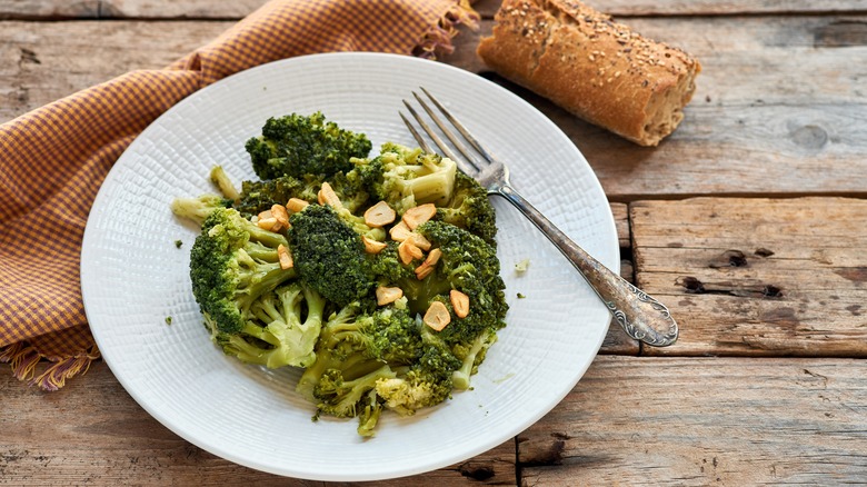 broccoli on a white plate topped with garlic