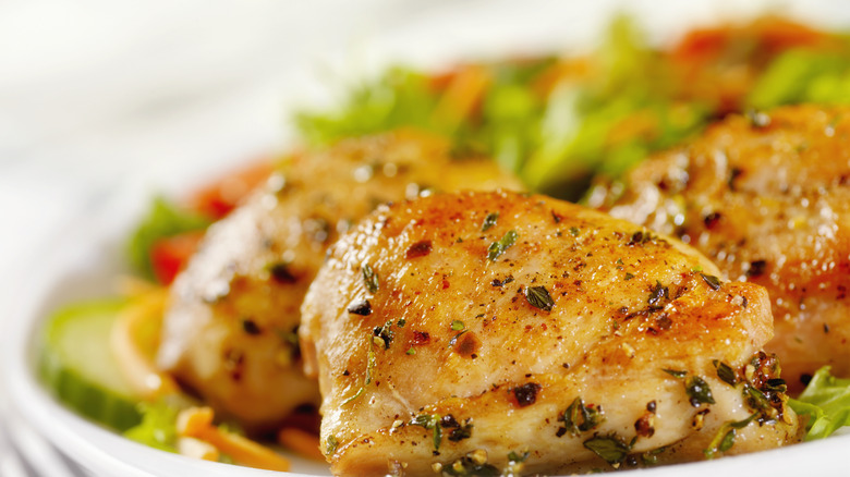 grilled chicken thighs plated with a side salad