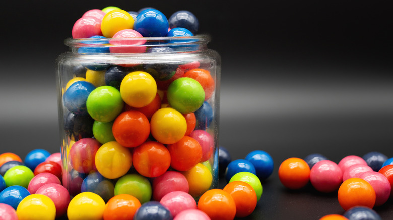 An overflowing jar of colorful gumballs