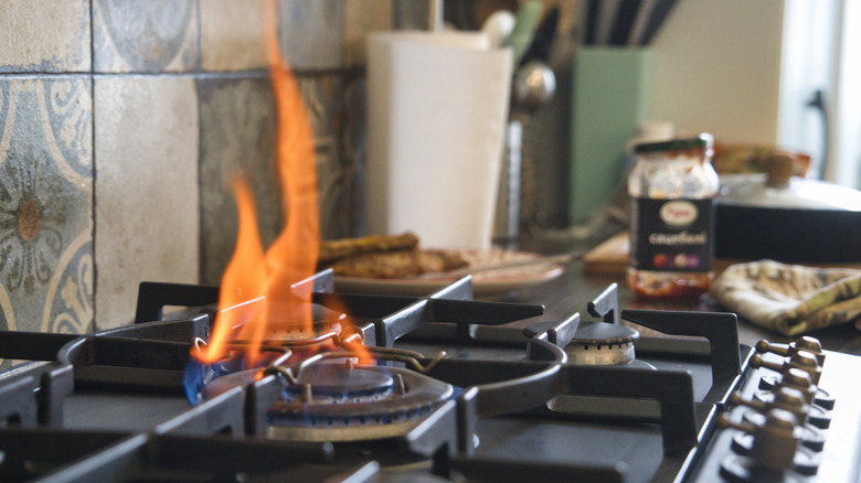 a stovetop burner on high with a large flame