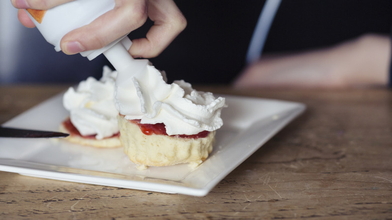 hand holding a can of whipped cream