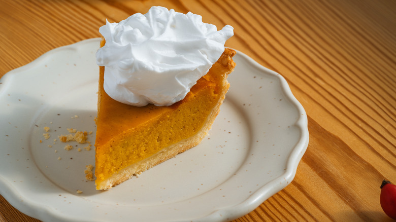piece of pumpkin pie with whipped cream on top