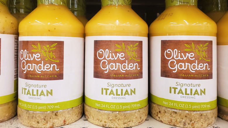 Three bottles of Olive Garden Signature Italian Dressing on a store shelf