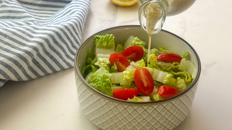 pouring dressing on salad