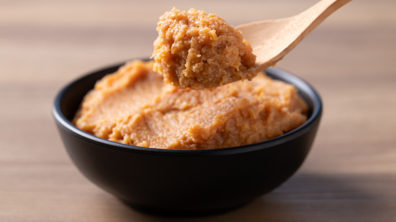 A bowl and a spoon full of miso paste.