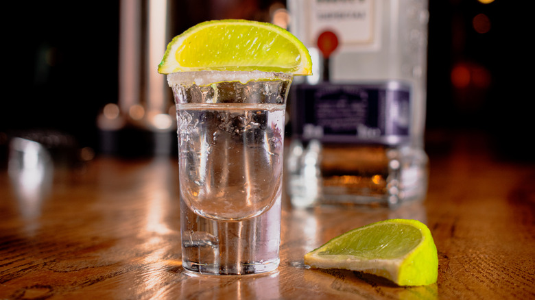 Tequila shots with lime wedge chasers ready on the bar