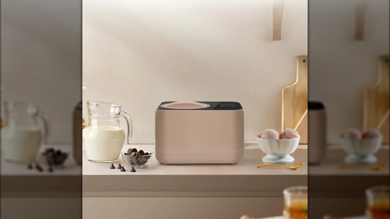 Personal Compact Ice Cream Maker with milk jug, chocolate chips, and ice cream bowl on the side