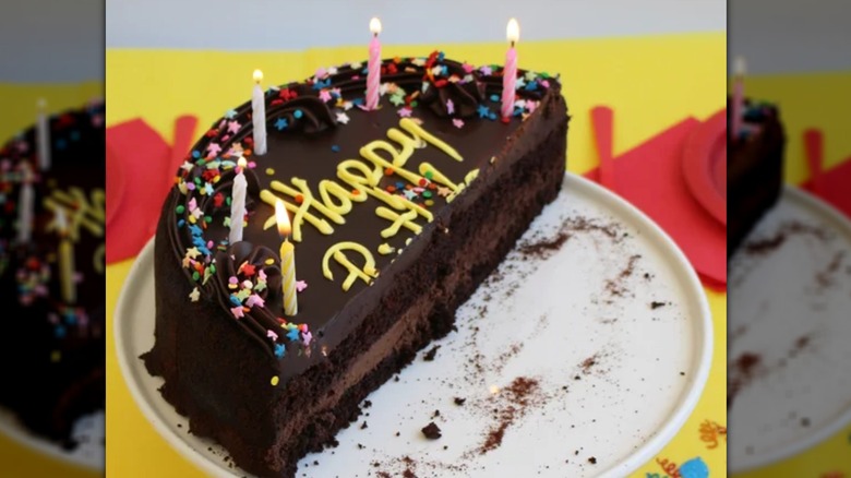 David's Chocolate Cake on a plate cut in half with candles.