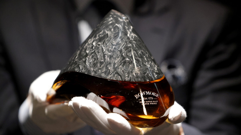 hands holding a bottle of Bowmore whisky