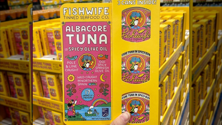 Person's hand holding up Fishwife tuna in a Costco