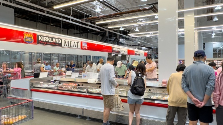 Customers shopping in the meat section of a typical Costco store.