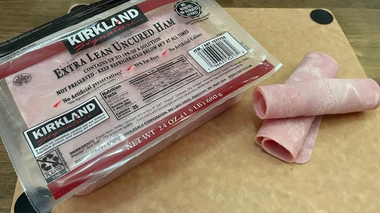 A package of Kirkland Extra Lean Ham plus a couple of rolled slices on cutting board.