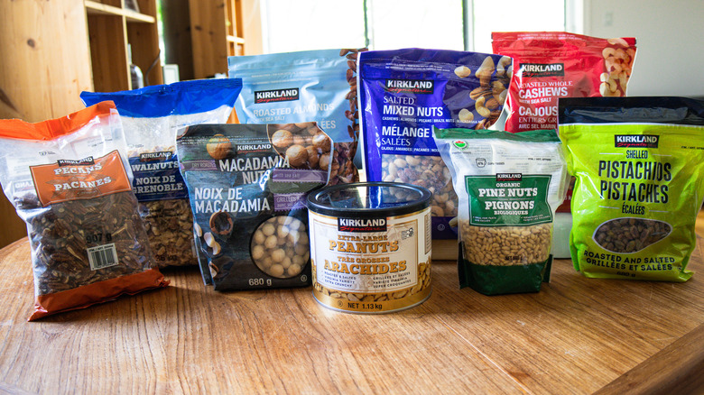 Nine of Costco's Kirkland Signature nuts in a row on a table.
