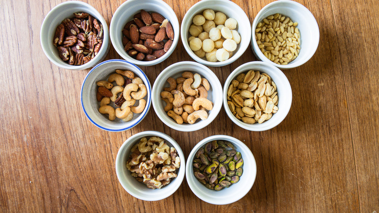 Nine of Costco's Kirkland Signature nuts in ramekins on a table.