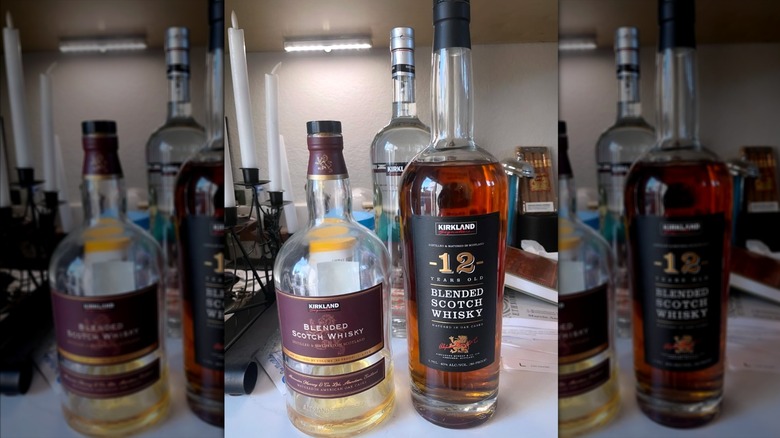 Kirkland Signature Blended Scotch Whisky next to a 12 year aged bottle on countertop in residential home.