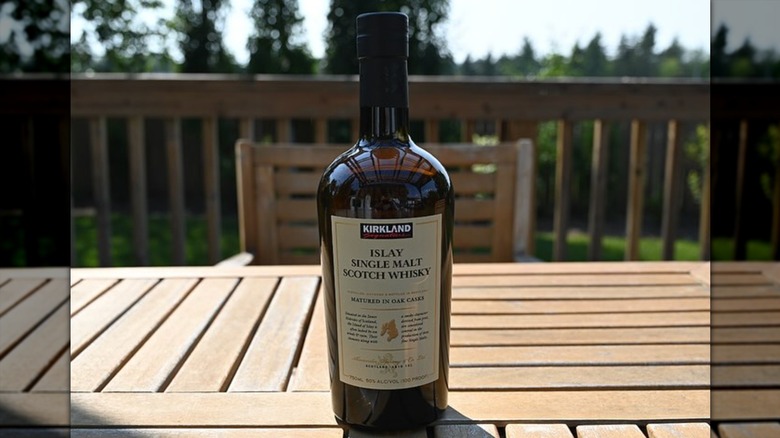 Kirkland Islay Single Malt Whisky bottle on outdoor table in residential home.