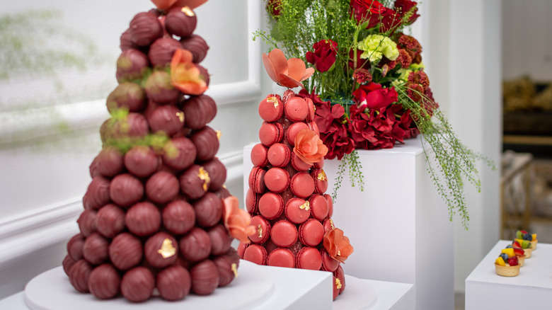 Macaron tower next to other sweets and floral arrangements.