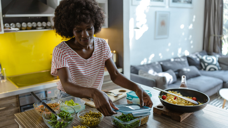 A person meal prepping with various ingredients in bowls