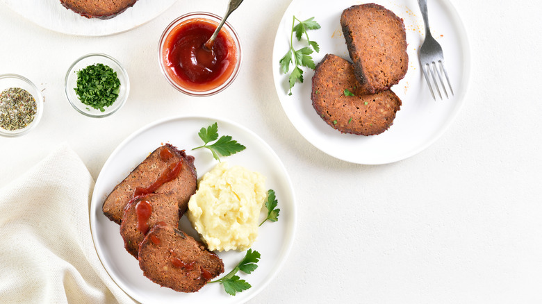 Meatloaf with mashed potato on plate over white background