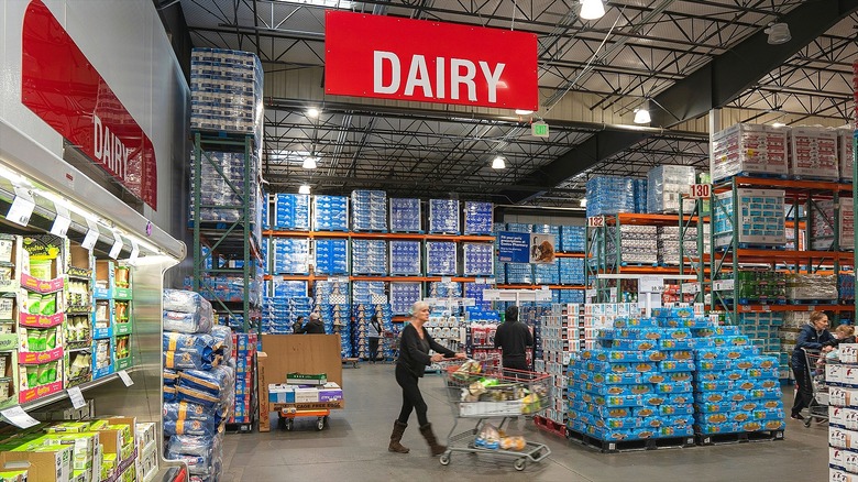Woman walking a grocery cart through the dairy department at Costco