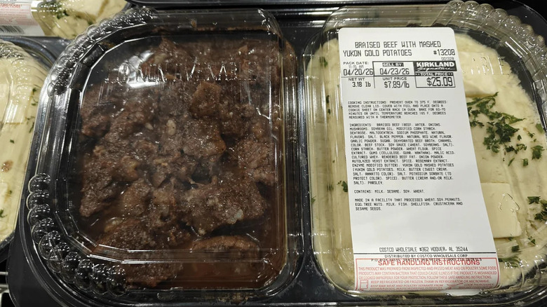 A container of Costco braised beef with mashed potato with a plastic lid.